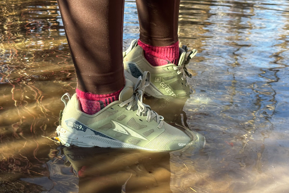 A pair of Altra shoes seen close up standing in a pool of water. 