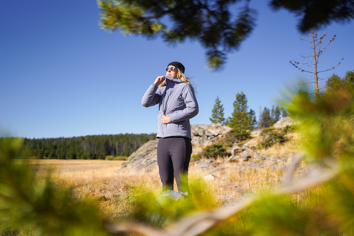 A woman zipping up a synthetic jacket in Wyoming