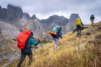 A group of hikers traverse a rocky mountain ridge in the Wind River mountains.