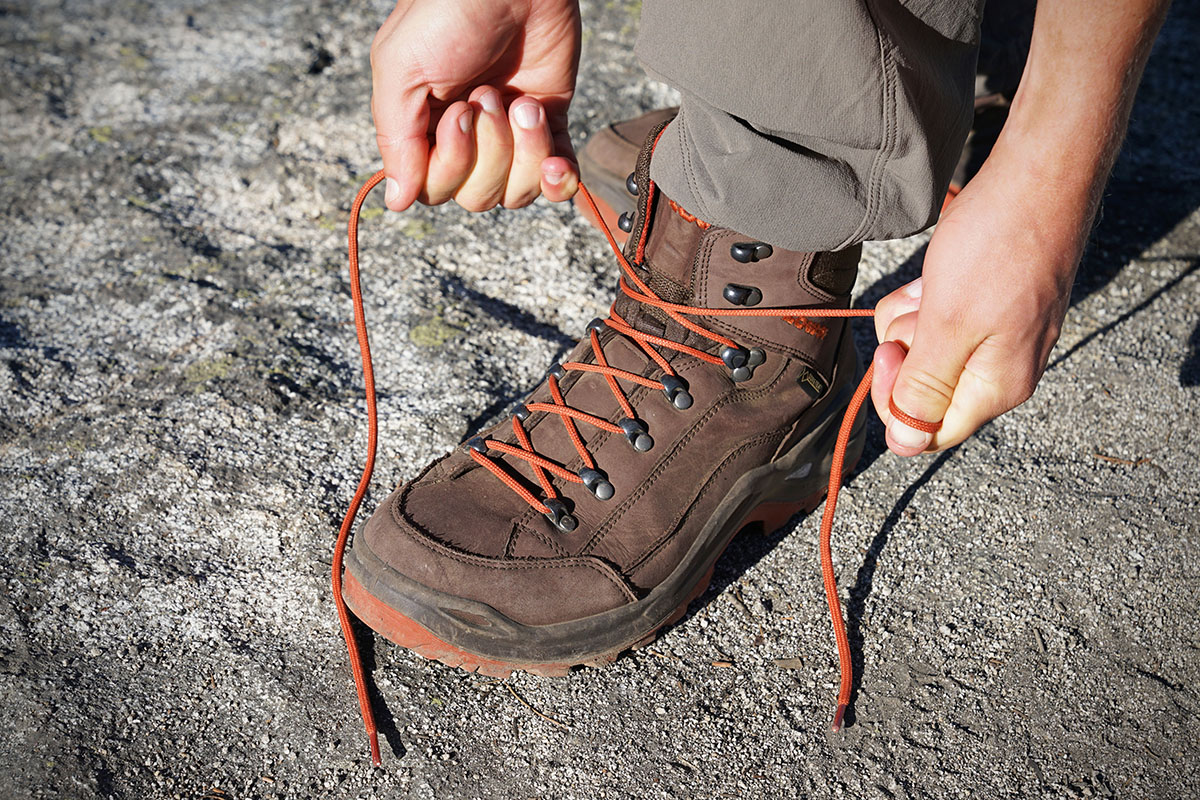 Bright orange laces add a fun touch to a pair of brown hiking boots.