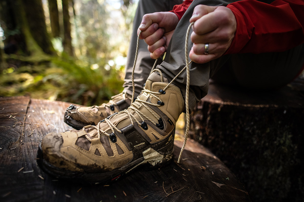 A hiker tightly laces up their boots.