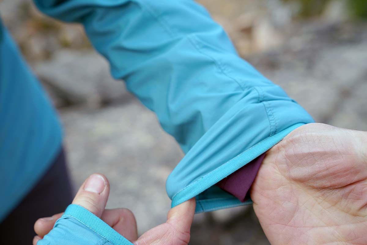 A tester demonstrates the elastic around the arm cuffs of a windbreaker.