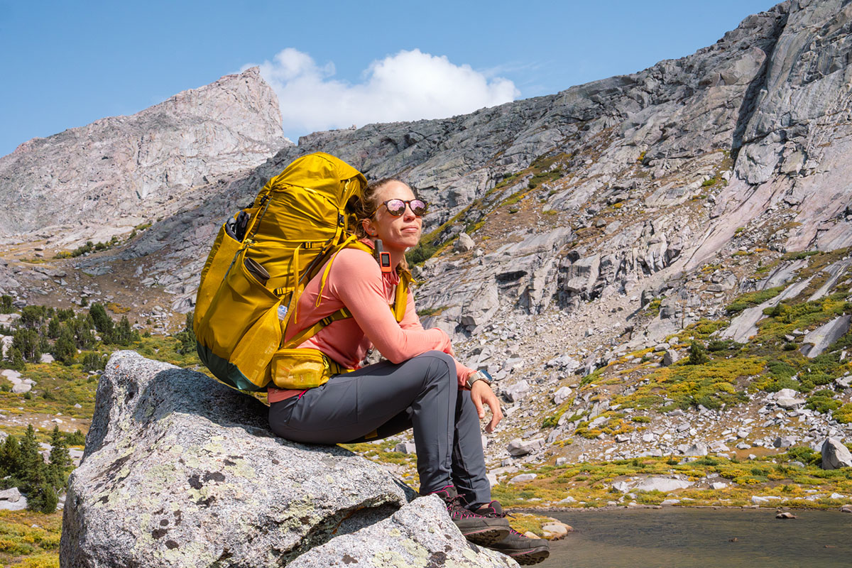 woman sitting on rock wearing Rab Elevation