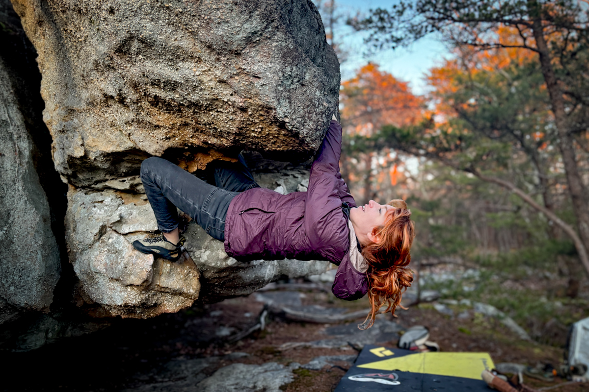 a woman bouldering in a synthetic jacket