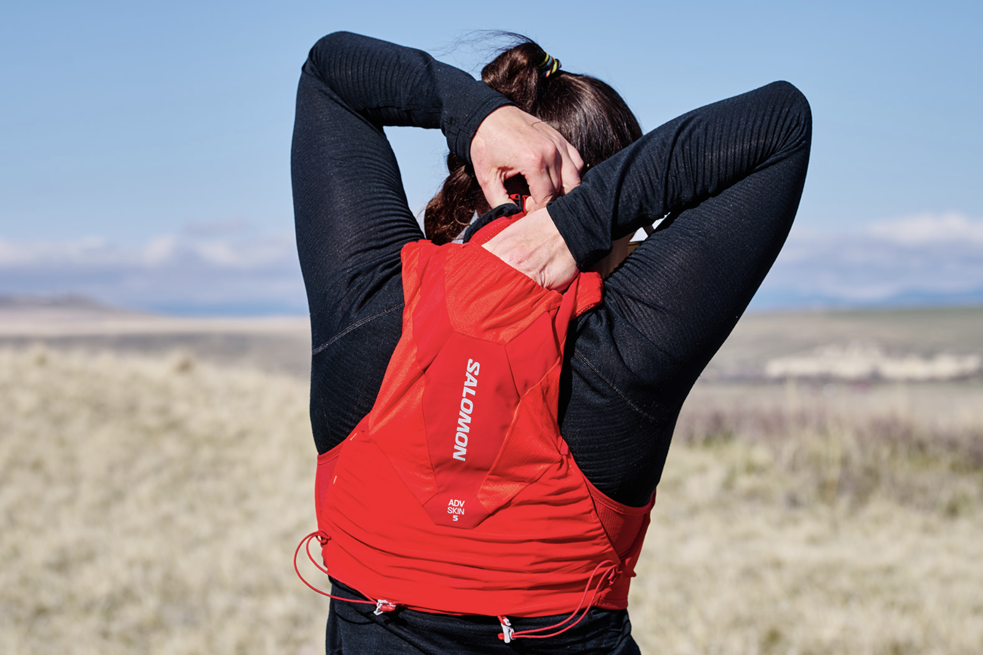 rear view of a woman reaching into a running pack 